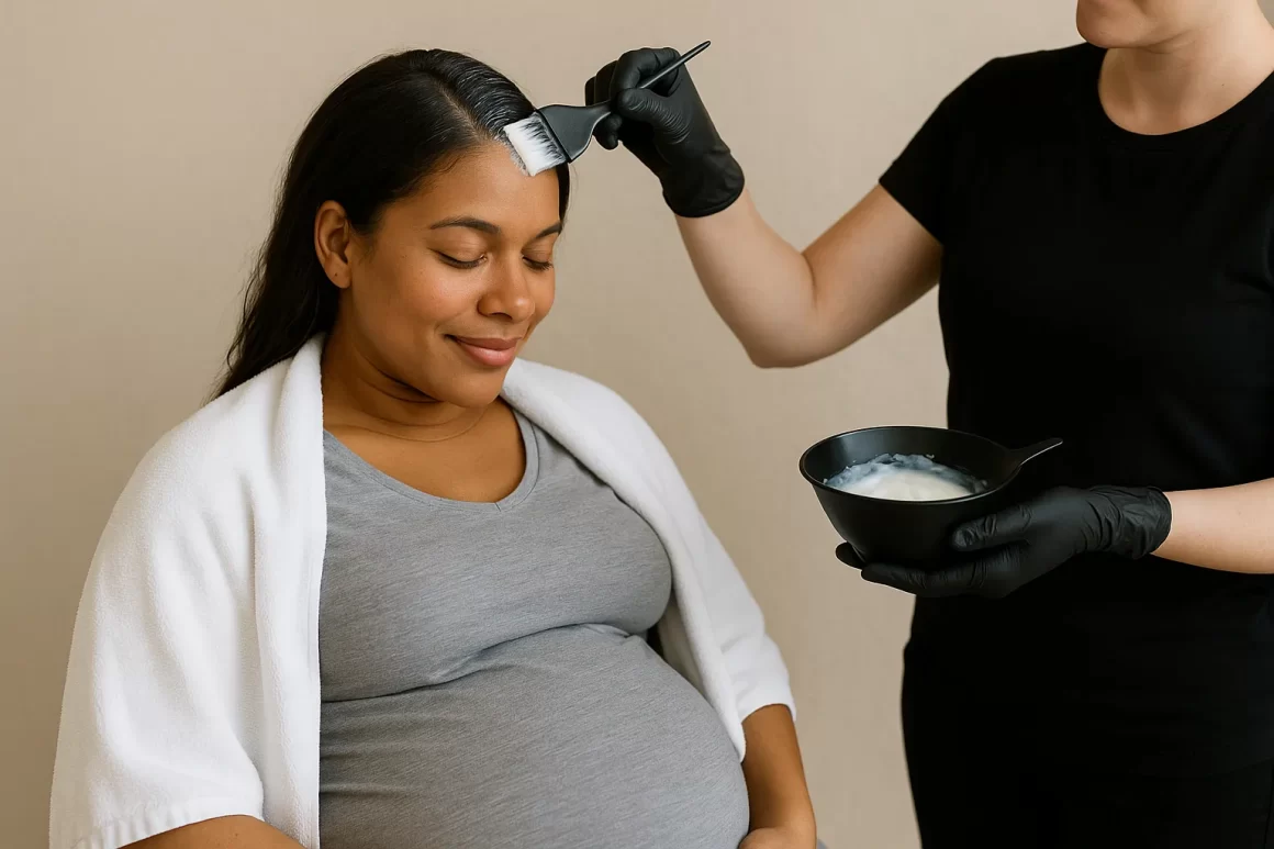 Mujer embarazada de piel morena recibiendo aplicación de tinte para el cabello en salón profesional, mostrando su vientre redondeado mientras sonríe relajada, con estilista aplicando coloración cuidadosamente.