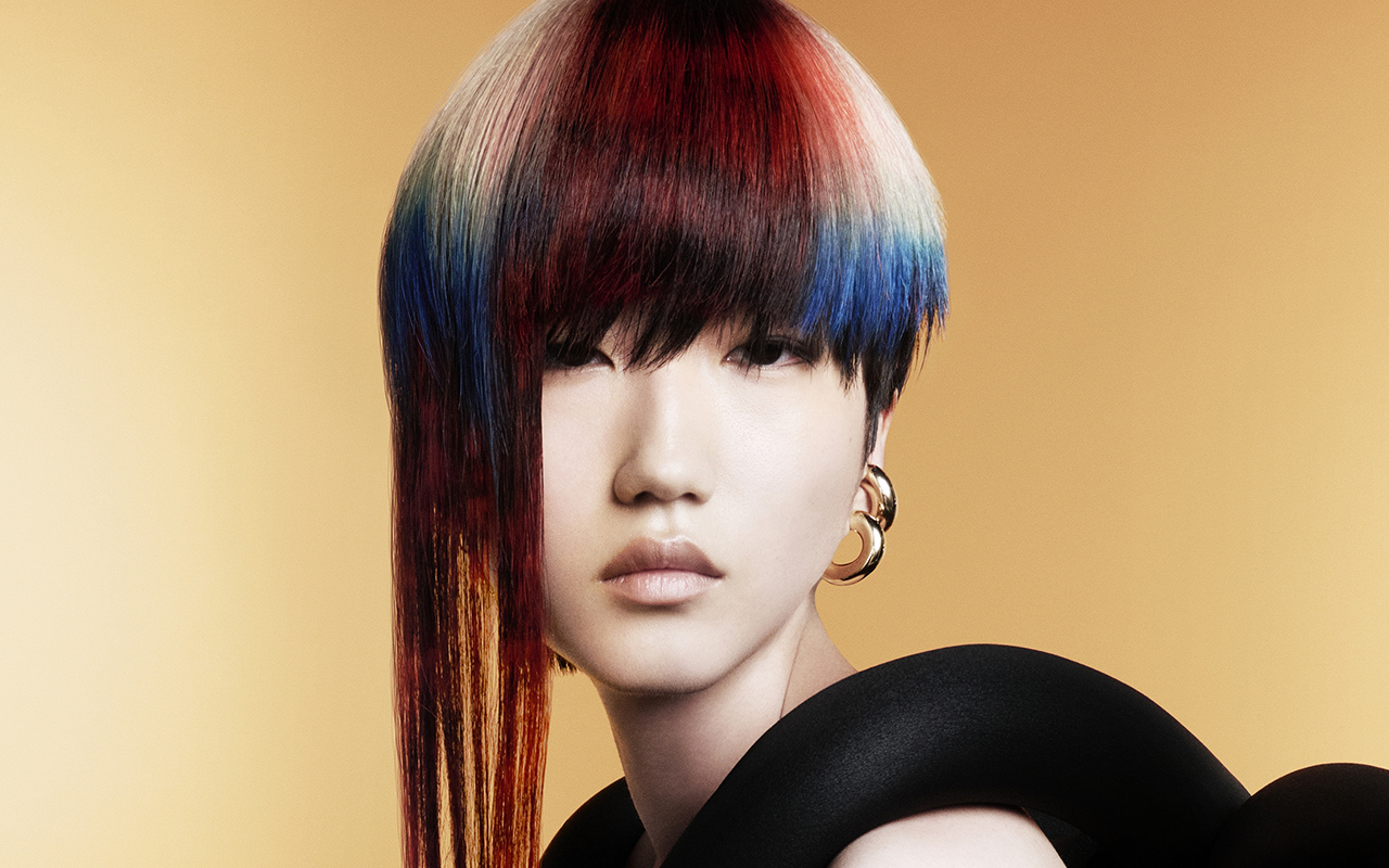 Corte asimétrico con tonos rojo, azul y blanco en acabado espejo, envuelto en escultura textil negra