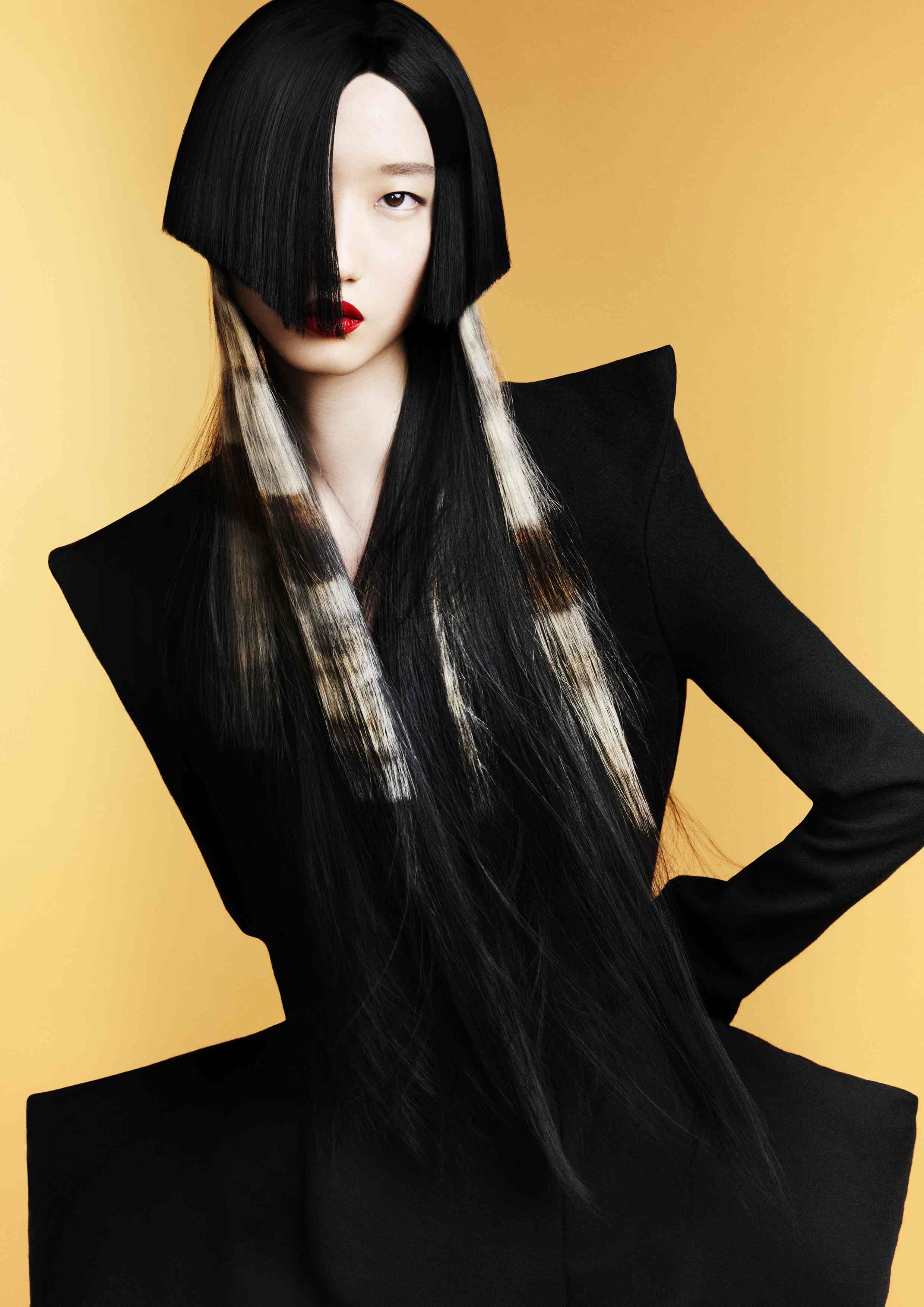 Cabello largo negro con sección frontal angular y mechas rubias tipo animal print, peinado arquitectónico