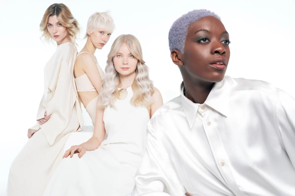 Grupo de cuatro modelos: bob texturizado rubio, pixie platinado, lob ondulado rubio y afro corto lila, estilismo monocromático blanco Alfaparf tonos perlados