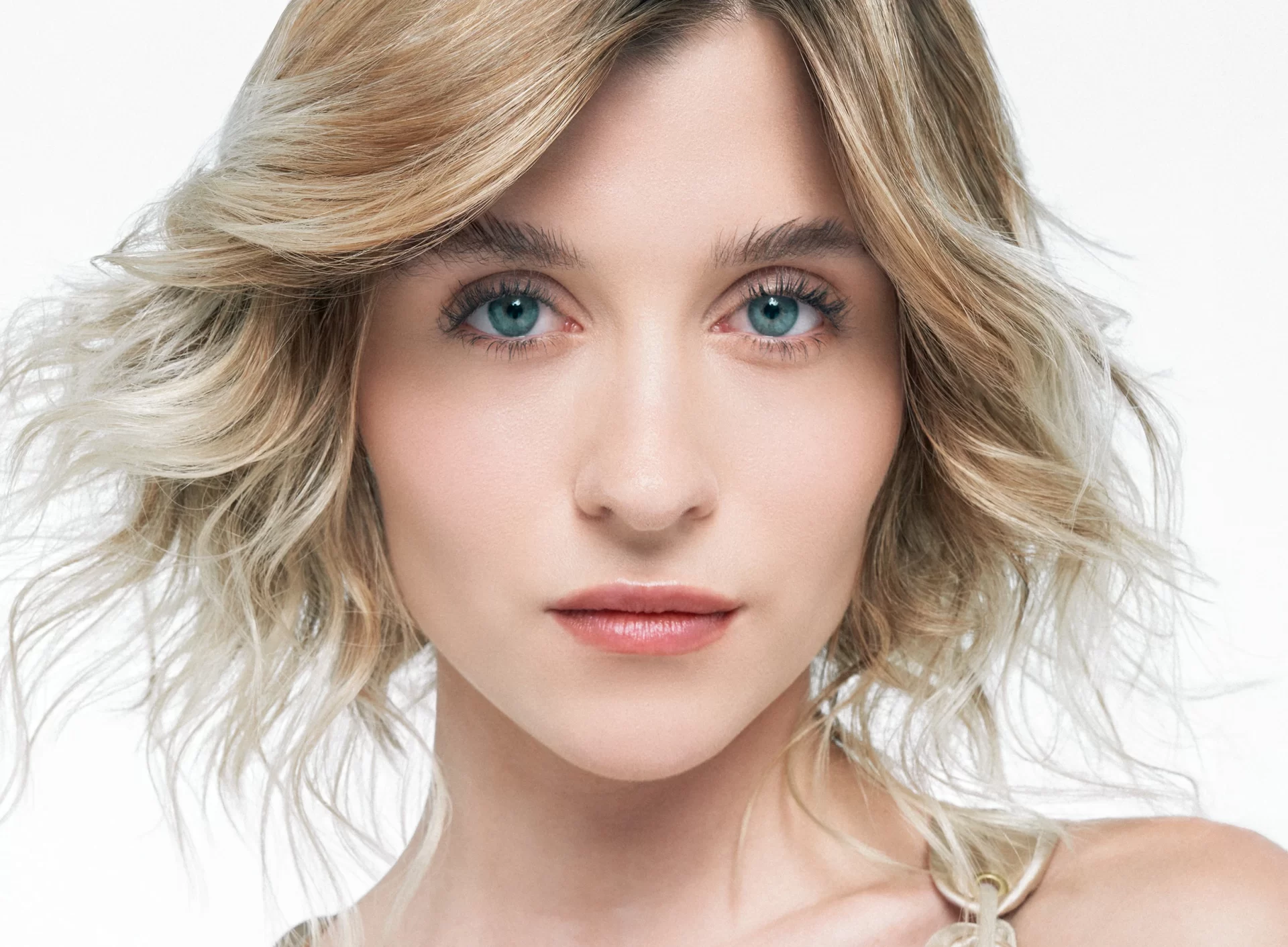 Primer plano de mujer con bob rubio y maquillaje natural Alfaparf tonos perlados