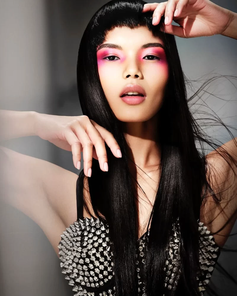 Modelo con cabello negro ultra liso, flequillo corto y maquillaje rosa neón, colección Freedom por Kerry Mather.