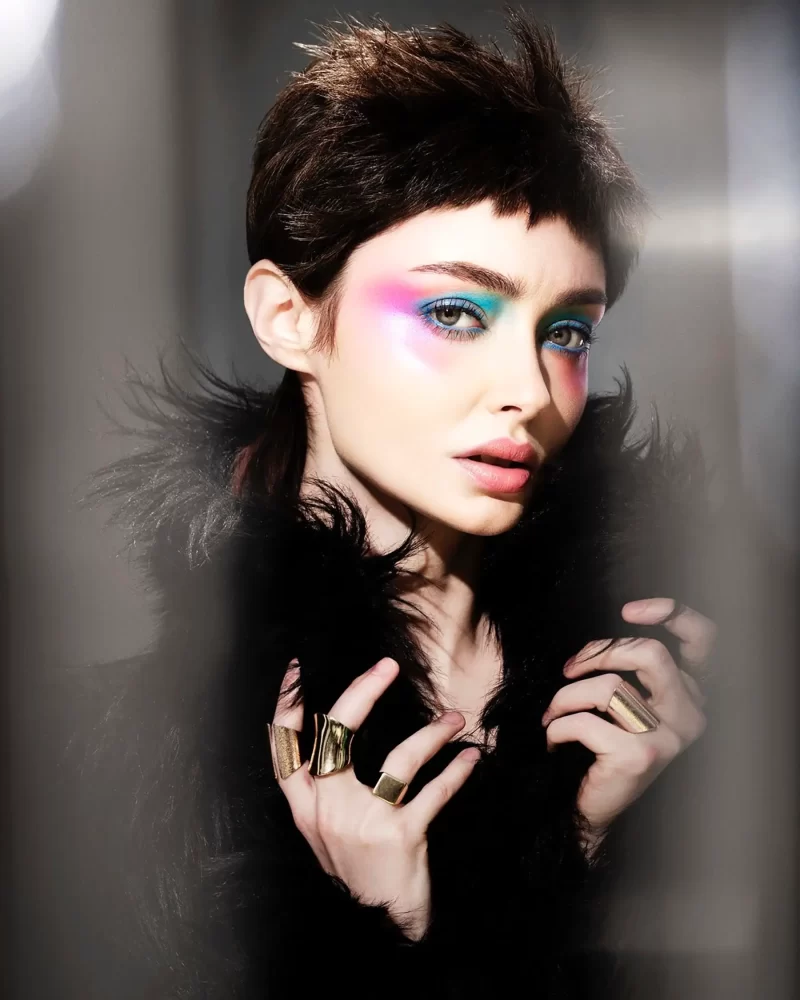 Modelo con corte pixie shaggy oscuro, volumen en la parte superior y maquillaje vibrante, colección Freedom por Kerry Mather.