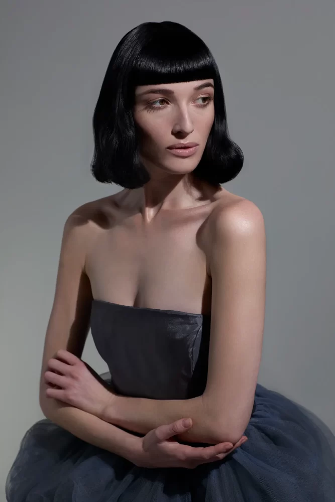 Mujer con elegante corte bob clásico y flequillo recto, creación de la colección Iconic por Sassoon Academy.