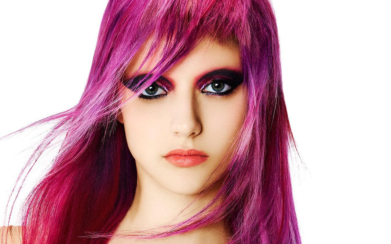 Modelo con cabello largo fucsia eléctrico y fleco texturizado, look editorial de alto impacto de la colección Skittles de George Alderete.