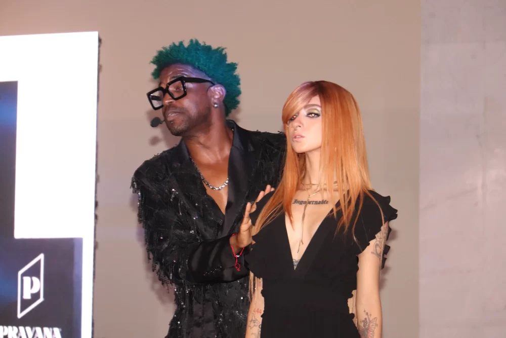 Timbo Mack y modelo de cabello rojo intenso posan en pasarela durante la demostración.