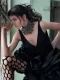 Modelo con flequillo recto y peinado mojado, vestida de negro con cuello de perlas negras.