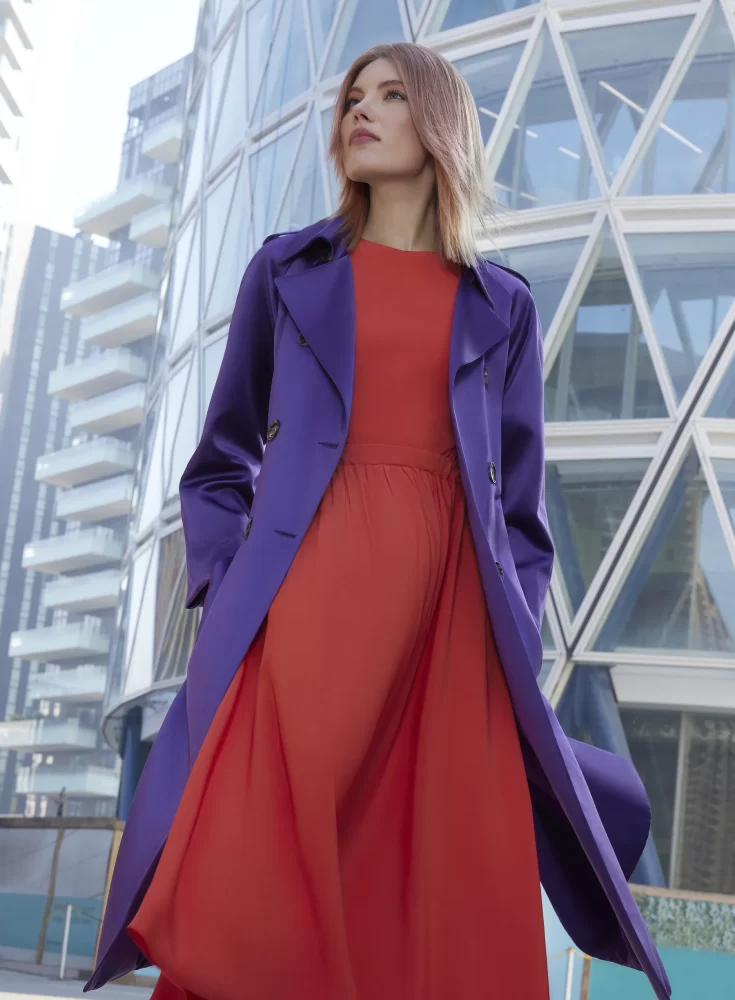 Modelo con corte pixie cobrizo, mirada intensa y fondo neutro de tonos grises y blancos.