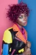 Modelo con cabello afro rizado en tono morado intenso, luciendo chaqueta de cuero multicolor con tachuelas. Colección Metaverso de Alexander Kiryliuk.