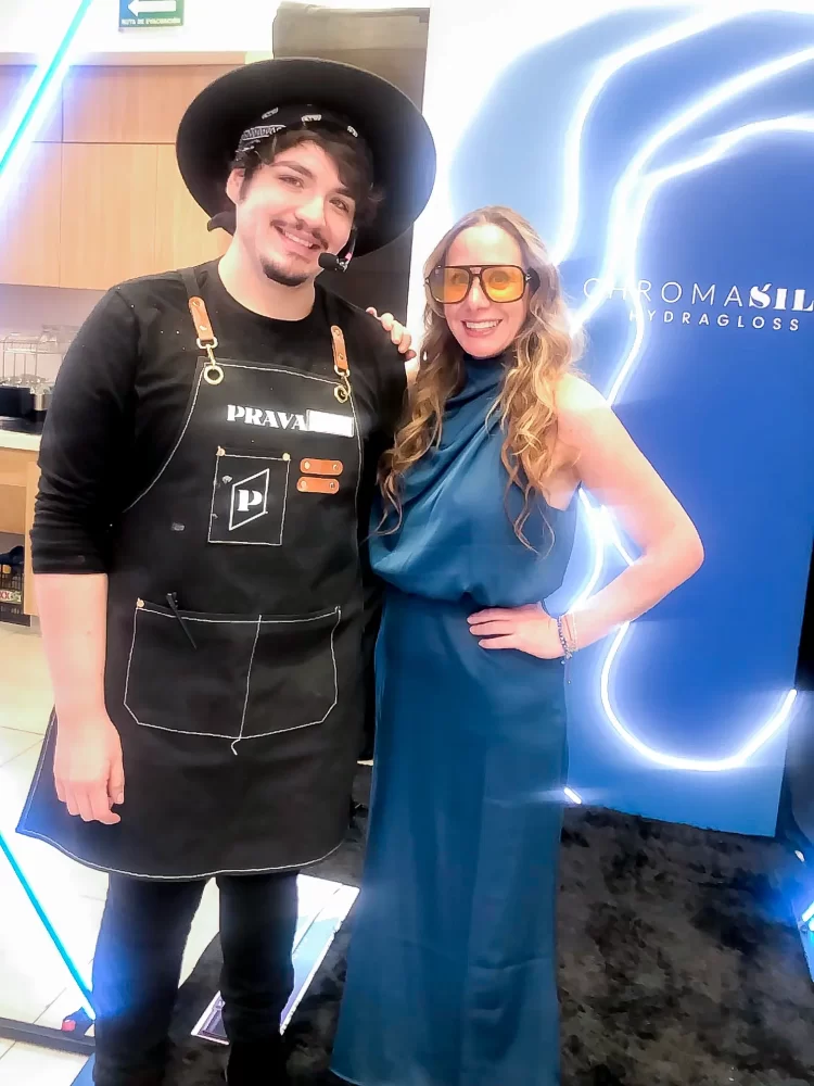 George Blanco y Laila Aruj posan frente a la imagen oficial de PRAVANA Hydragloss durante el evento en Ciudad de México.