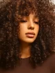 Mujer con cabello rizado voluminoso en tonos castaños cálidos, estilo natural de la colección Igora Zero de Schwarzkopf Professional.