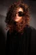 Rizos voluminosos en castaño con reflejos canela y gafas oscuras oversize.