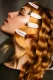 Ondas al agua en backstage sujetas con clips blancos sobre base dorada.
