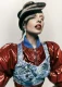 Modelo con peinado escultural tipo visor y labios rojos, chaqueta vinilo rojo y top denim; colección Fabric de Ben Martin