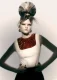Modelo con beehive voluminoso, mechón claro y detalle dorado; top blanco con cuello vinilo rojo; colección Fabric de Ben Martin.