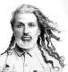 Modelo de la colección Real People de Craig Mason con cabello largo ondulado, barba clara y movimiento lateral en blanco y negro.